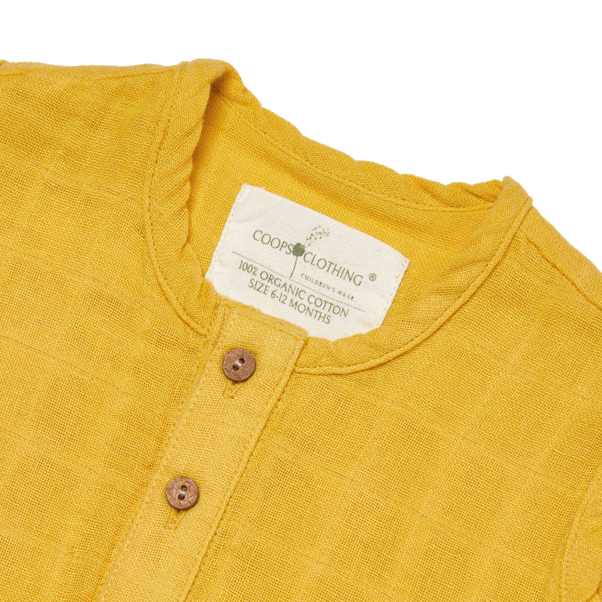 Yellow overall with a Coops Clothing label and coconut shell buttons on a white background