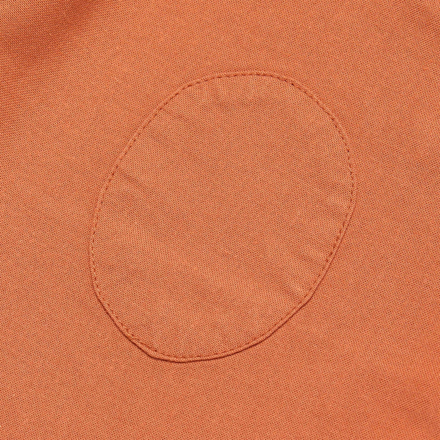 Close-up of a orange fabric pocket with stitching detail