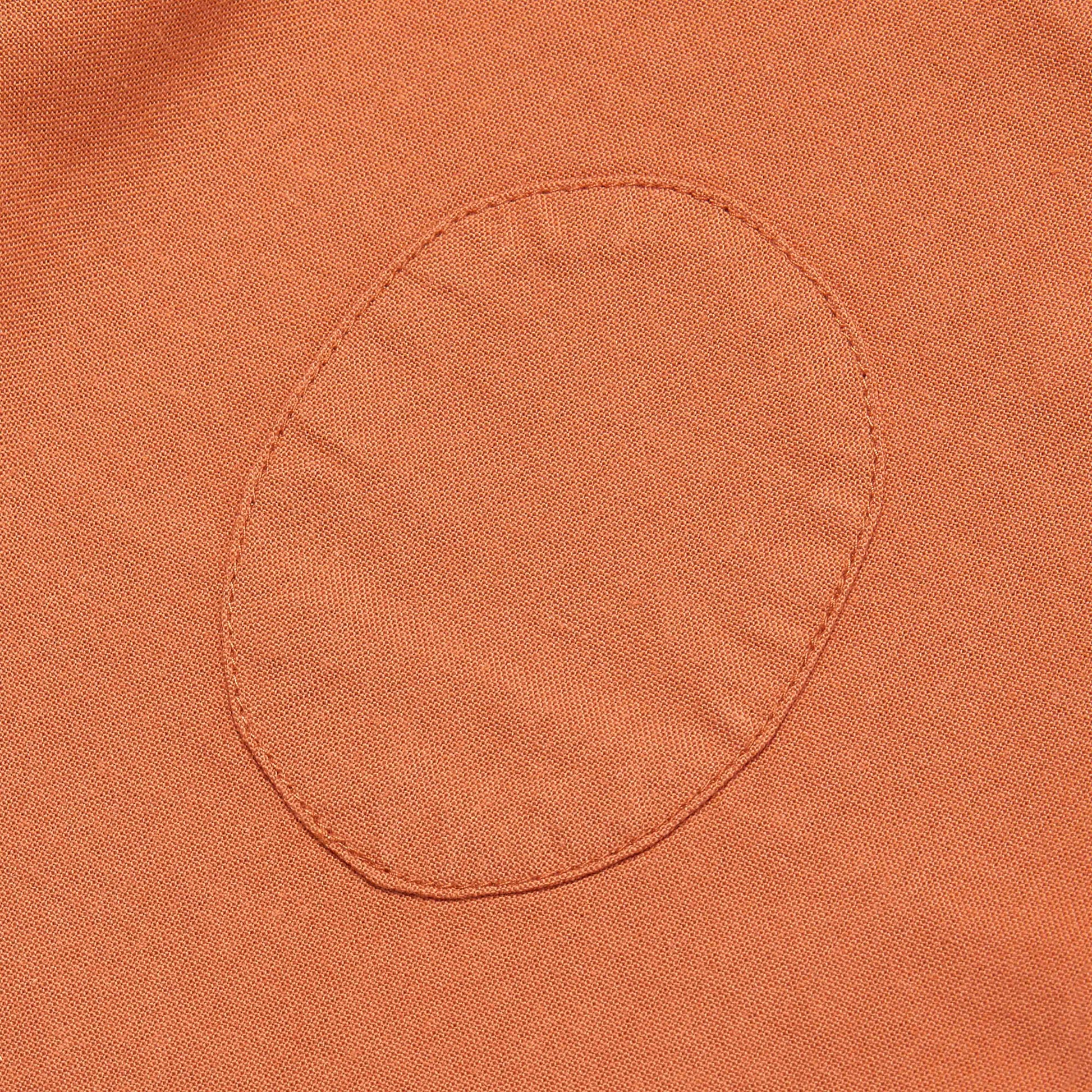 Close-up of a orange fabric pocket with stitching detail