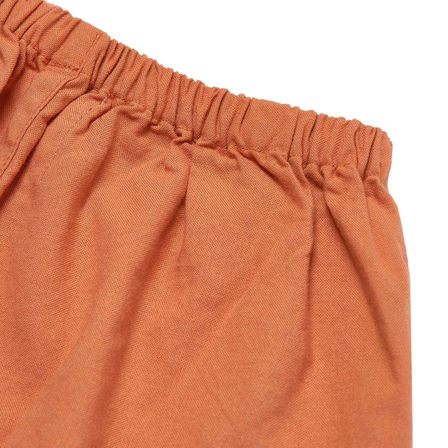 Close-up of orange pants with a white background